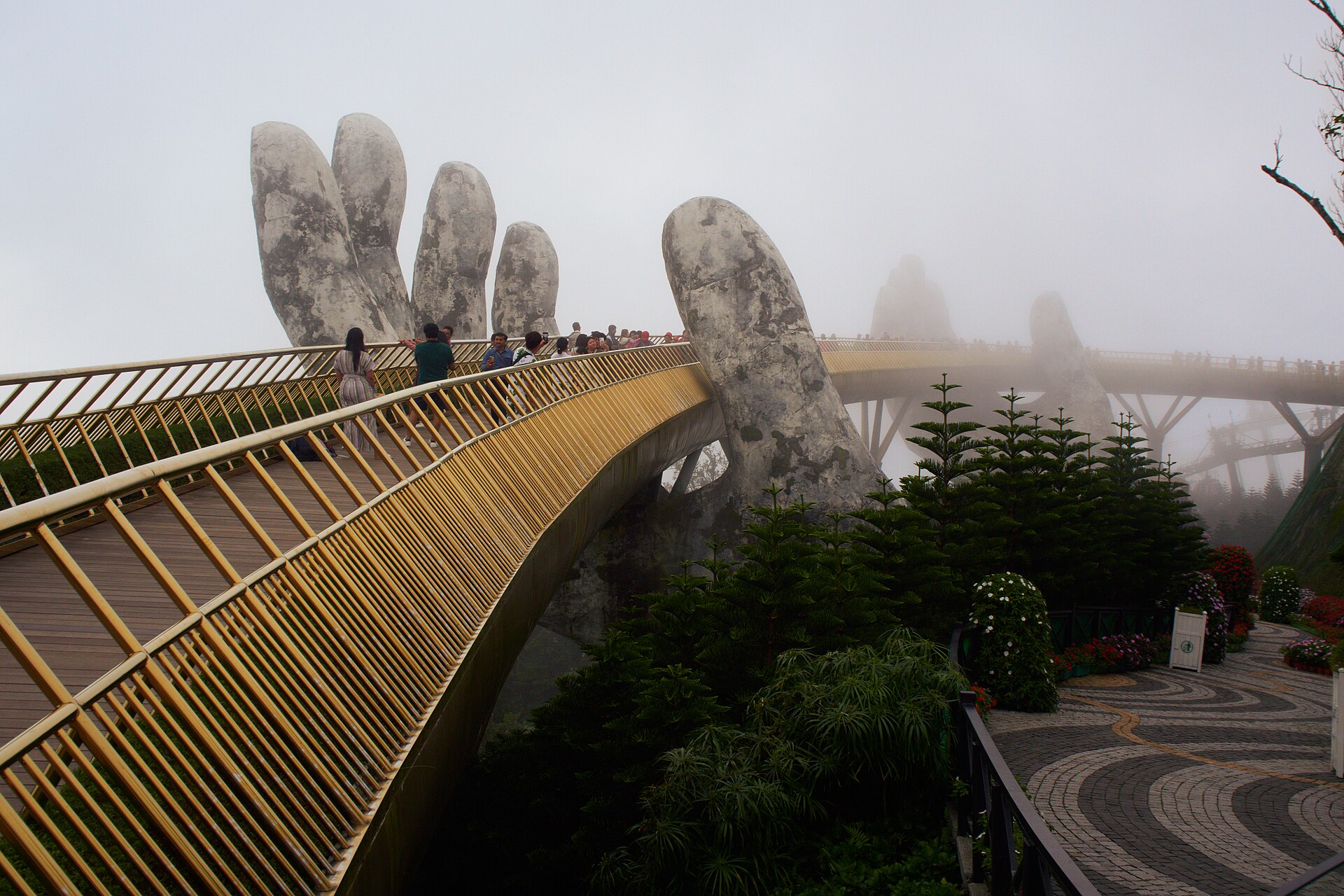 Visitors on the Golden Bridge in the mist at Ba Na Hills